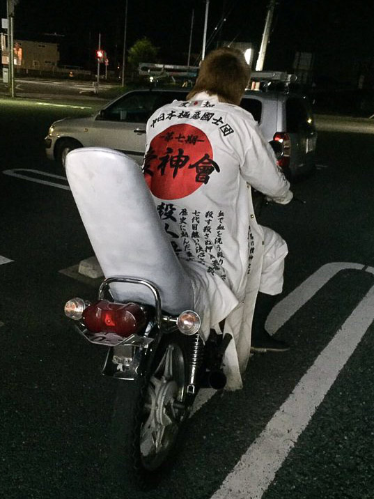 特攻服を着て三段シートのバイクにまたがる七代目愛神會のメンバー