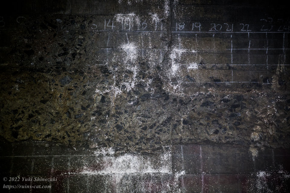 マス目が書かれたトンネル内の壁の裂け目