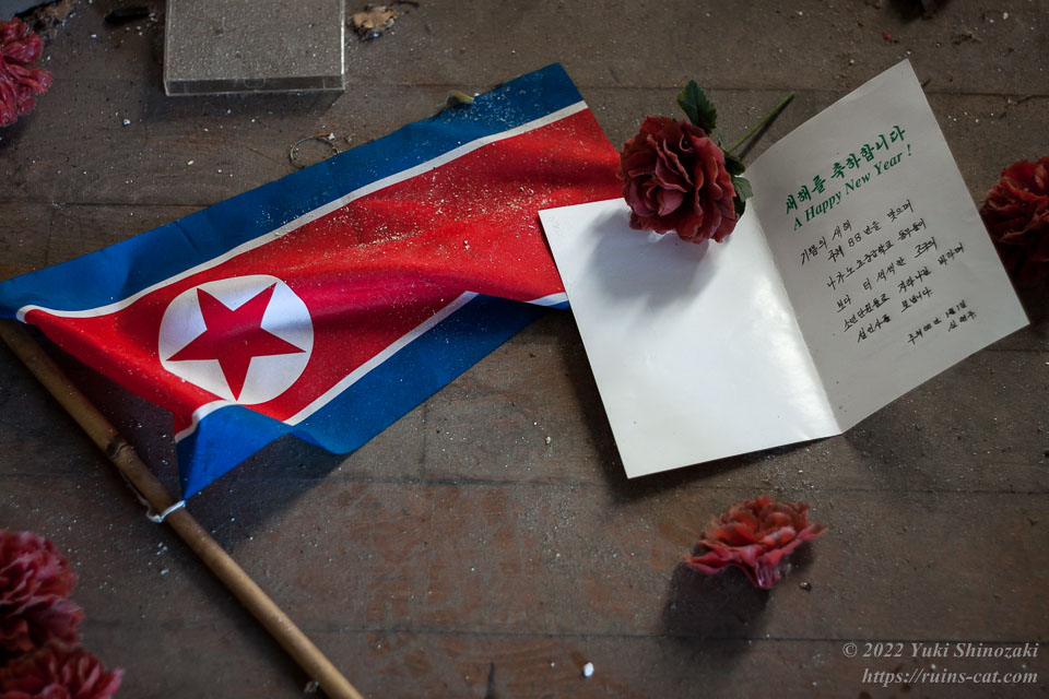 北朝鮮の国旗と主体88年を祝うメッセージカード